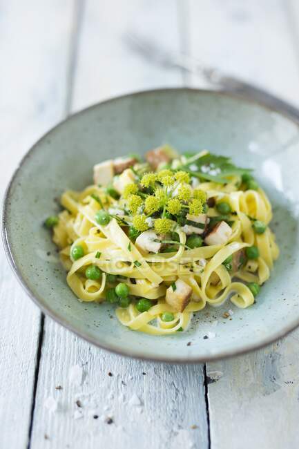 Ribbon noodles with smoked tofu and peas — Stock Photo