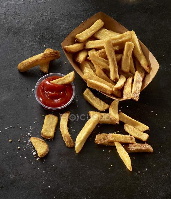 French fries in a cardboard box with ketchup — Stock Photo