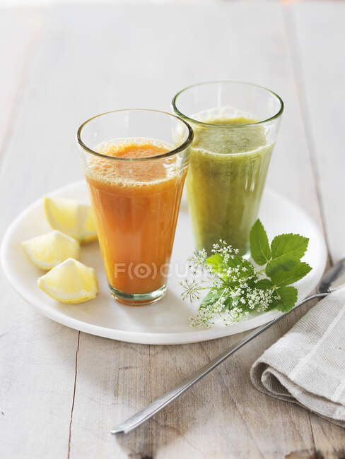 Glass of fresh juice with lemon and mint on white background — Stock Photo
