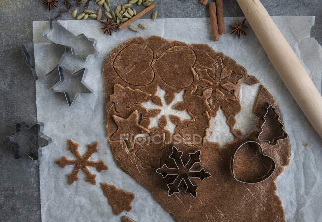 Vegan gingerbread biscuits being cut out of a rolled-out sheet of pastry — Stock Photo