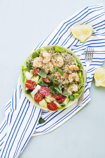Light summer gluten free lunch bowl with buckweat, cucumber, tomatoes and prawns on lettuce leaves — Stock Photo