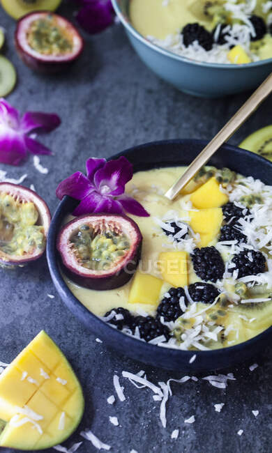 Frullato di mango condito con frutto della passione, orchidea, mora di rovo, kiwi giallo e cocco — Foto stock