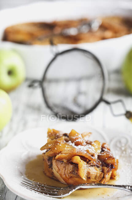 Apple French toast casserole with maple syrup and powdered sugar — Stock Photo