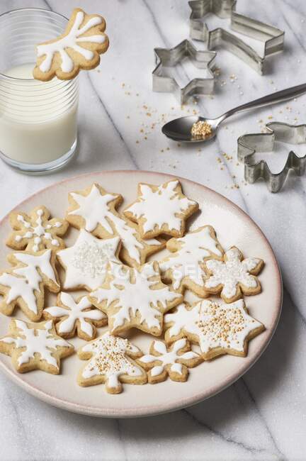 Glazed butter cookies, a glass of milk, and various cookie cutters — Stock Photo