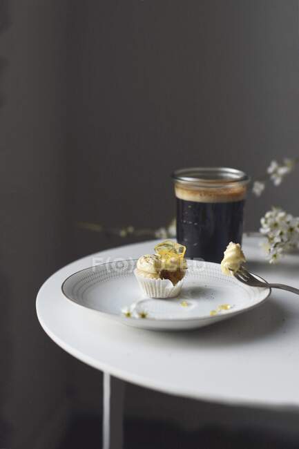 A mini lemon cupcake and coffee — Stock Photo