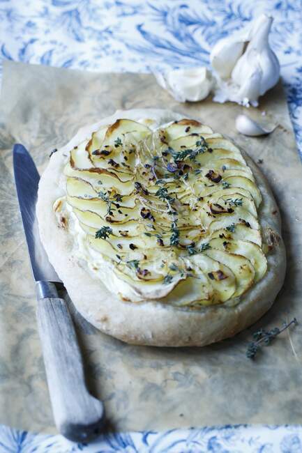 Pizza with fresh cheese, garlic, sliced potatoes, and thyme — Stock Photo