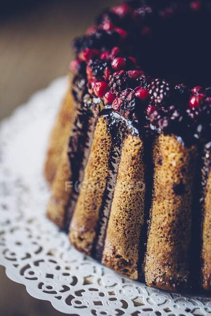 A ring-shaped Bundt cake with berries and chocolate glazing (detail) — Stock Photo