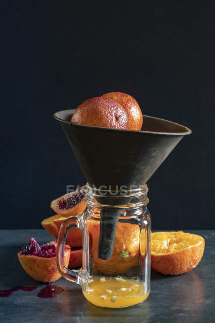 Laranjas e laranjas de sangue sendo suculentas em espremedor de mãos — Fotografia de Stock