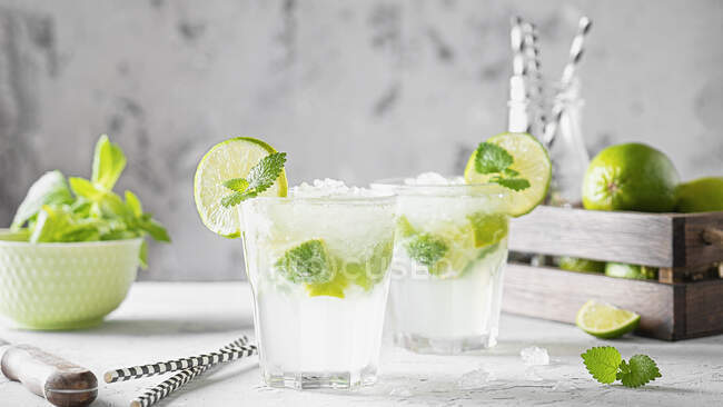 Mojito cocktails with mint leaves and lime slices — Stock Photo