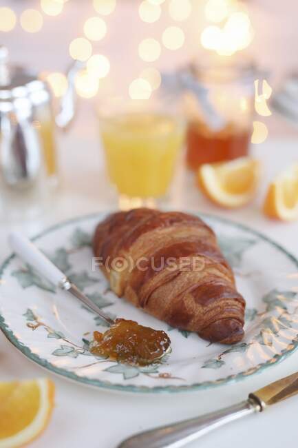 Um croissant com marmelada laranja — Fotografia de Stock