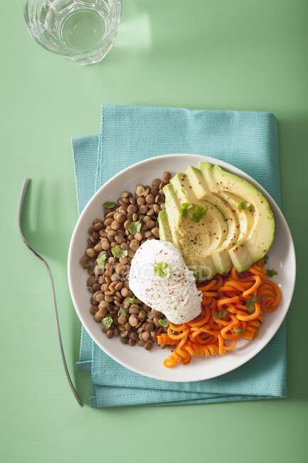 Spiralized carrot and avocado bowl with poached egg and lentils — Stock Photo