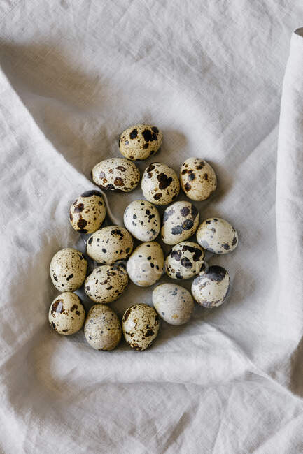 Quail eggs on white linen background — Stock Photo