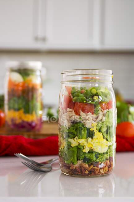 Salada em camadas em vidro com espinafre, feijão, queijo e ovo — Fotografia de Stock
