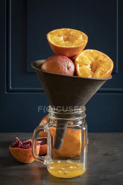 Arance e arance succhiate in uno spremiagrumi — Foto stock