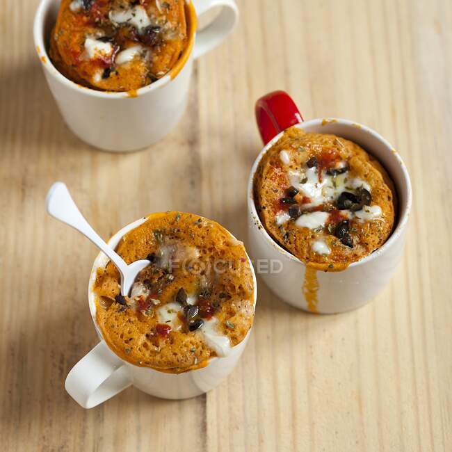 Savoury pizza mug cakes with olives, tomato and cheese — Stock Photo