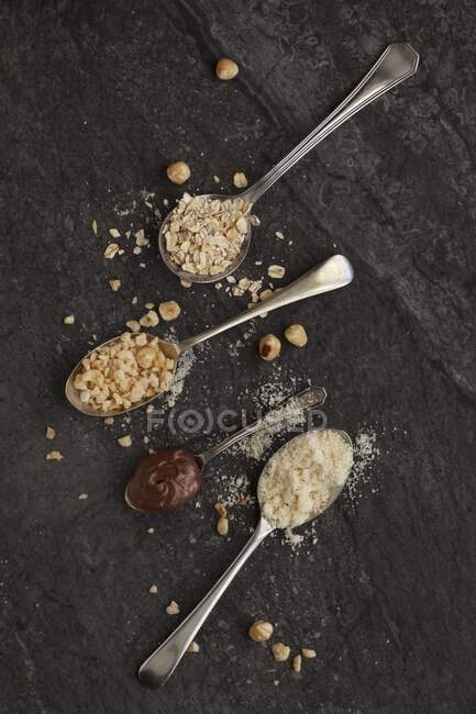 Вінтажні ложки з вівсом, подрібненими лісовими горіхами, меленим мигдалем та шоколадом горіхами — стокове фото