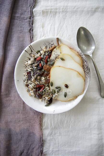 Porridge with chia, goji berries, and pear slices — Stock Photo