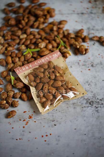 Roasted rosemary and chilli almonds, with some packaged — Stock Photo