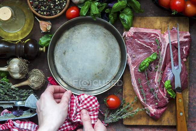 Raw T-Bone steak with pan and various ingredients — Stock Photo
