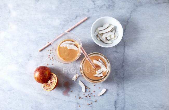 Batido de naranja con manzana, coco y linaza - foto de stock