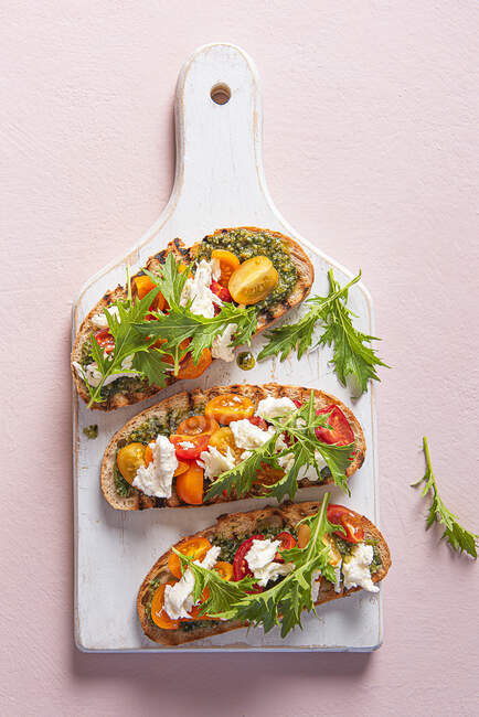 Хліб на грилі з песто, сиром моцарелла, помідорами та ракетним салатом — стокове фото