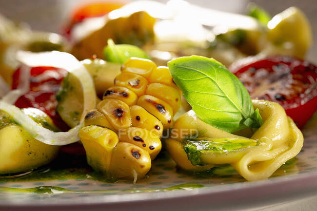 Тортеллини с помидорами, жареной кукурузой и базиликовым песто — стоковое фото
