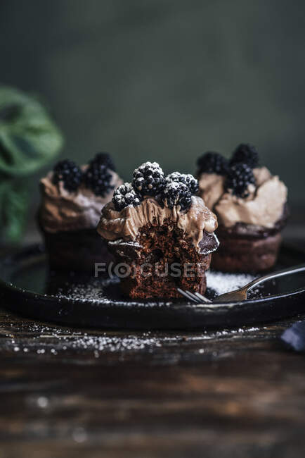 Chocolate cupcakes with coffee cream and blackberries — Stock Photo