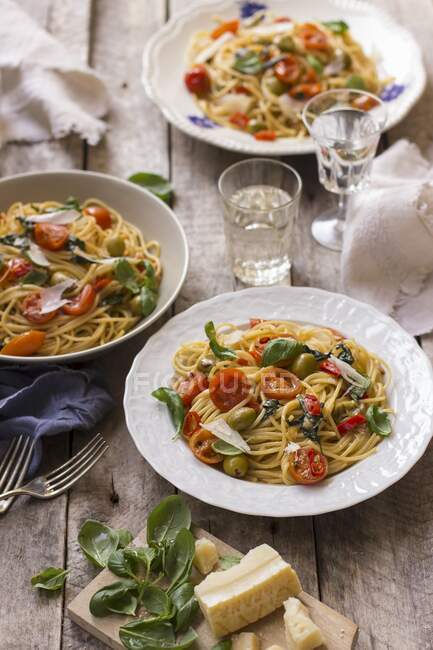 Spaghetti con pomodorini, basilico fresco, olive, peperoncino e parmigiano — Foto stock