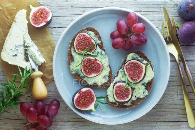 Pane alla griglia con gorgonzola, fichi e uva sul piatto — Foto stock