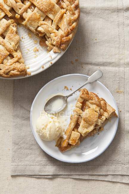 Шматок яблучного пирога з ванільним морозивом на тарілці — стокове фото