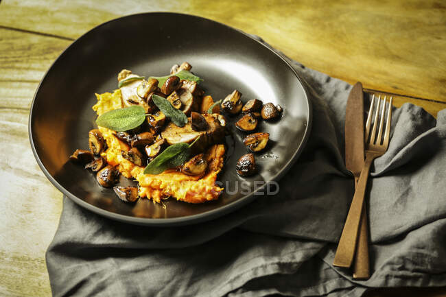Pork fillet with mushrooms and fried sage on a bed of mashed sweet potatoes — Stock Photo