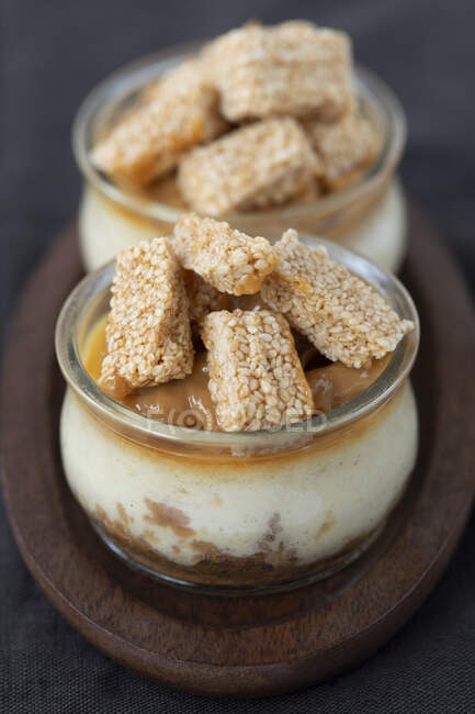 Cheesecakes with sesame bars in jars — Stock Photo