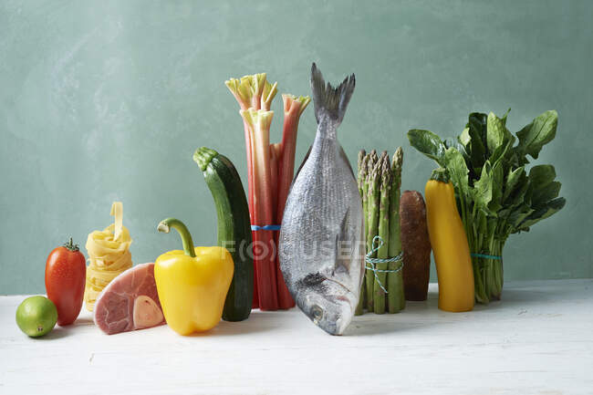 An arrangement of vegetables with fish, meat and pasta — Stock Photo
