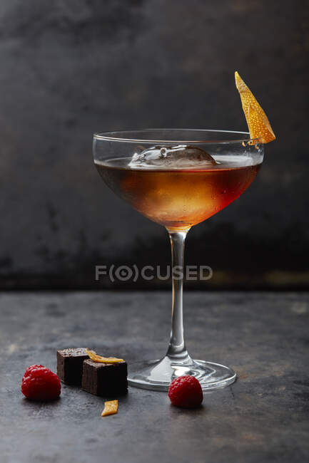 Cocktail with ice cube and dried orange peel — Stock Photo