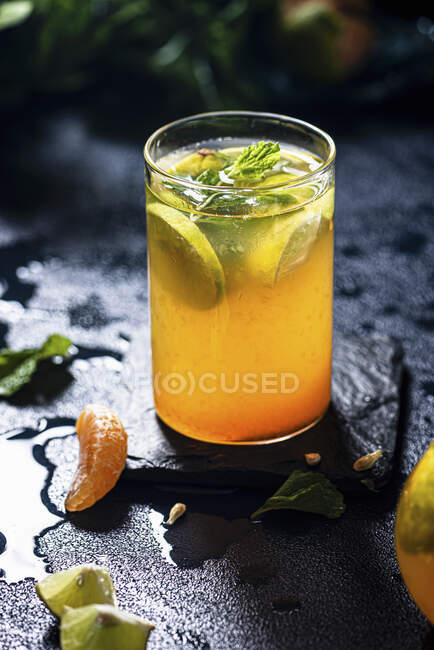 Bebida de sharbat naranja y menta en vaso con hojas de menta - foto de stock