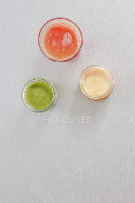 Frullato verde, succo di limone e succo d'arancia nei bicchieri — Foto stock