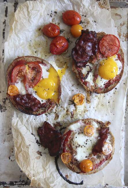 Pan tostado con tocino, tomates y huevos fritos para el desayuno - foto de stock