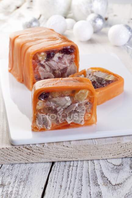 Goose breast in jelly with raisins and cranberries wrapped in carrots sliced — Stock Photo