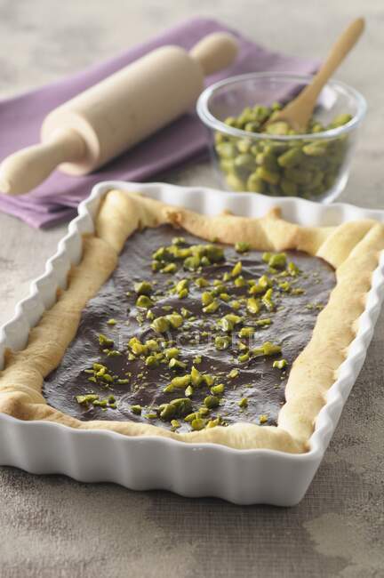 Chocolate tart with pistachios in a square-shaped baking dish — Stock Photo