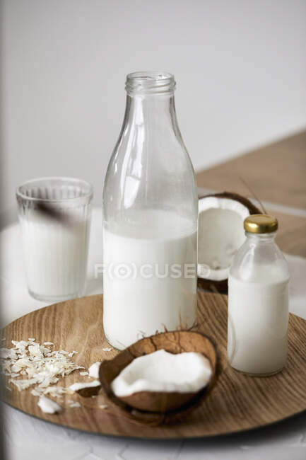 Frascos de leche y vidrio de copos de avena sobre un fondo de madera blanco - foto de stock