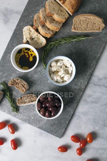 Mezze griego: aceitunas, feta, aceite de oliva y pan - foto de stock