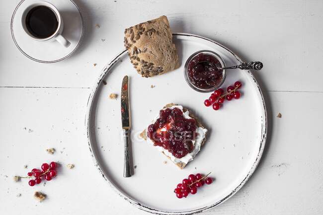 Bread and jam on a white wooden board with a cup of coffee (seen from above) — Stock Photo