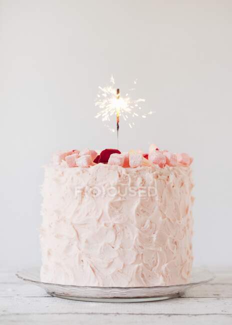 Turkish Delight layer cake with a sparkler candle — Stock Photo