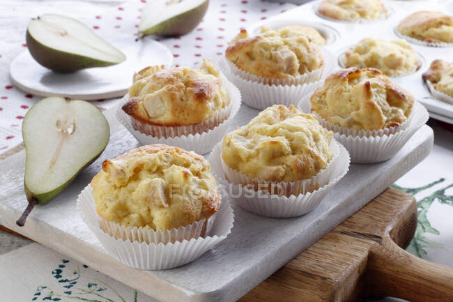 Tasty muffins with fruits and vegetables on wooden board — Stock Photo