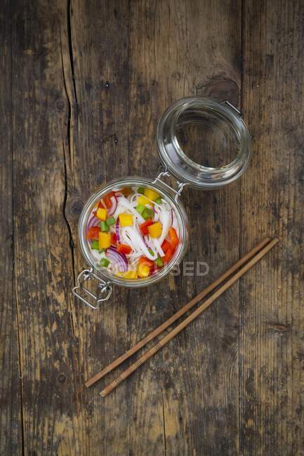 Стеклянный салат из лапши с желтым и красным перцем, луком и красным луком — стоковое фото