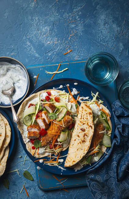 Wraps with panko coated chicken, minted yoghurt, tomato salsa, cucumber and cabbage and carrot slaw — Stock Photo