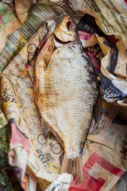 Сушеная рыба в старой газете — стоковое фото