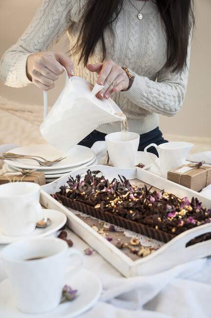 Une tarte au chocolat et noisette et des tasses de thé — Photo de stock