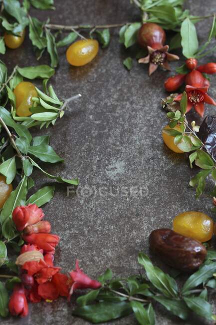 Stillleben mit Datteln, kandierten Früchten und Granatapfelzweigen — Stockfoto