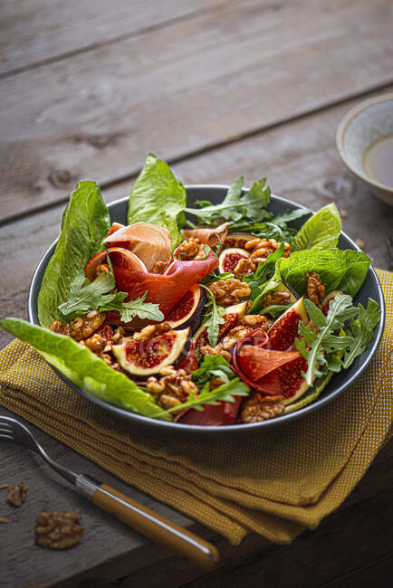 Salad with figs, ham, roasted walnuts and vinegar dressing — Stock Photo